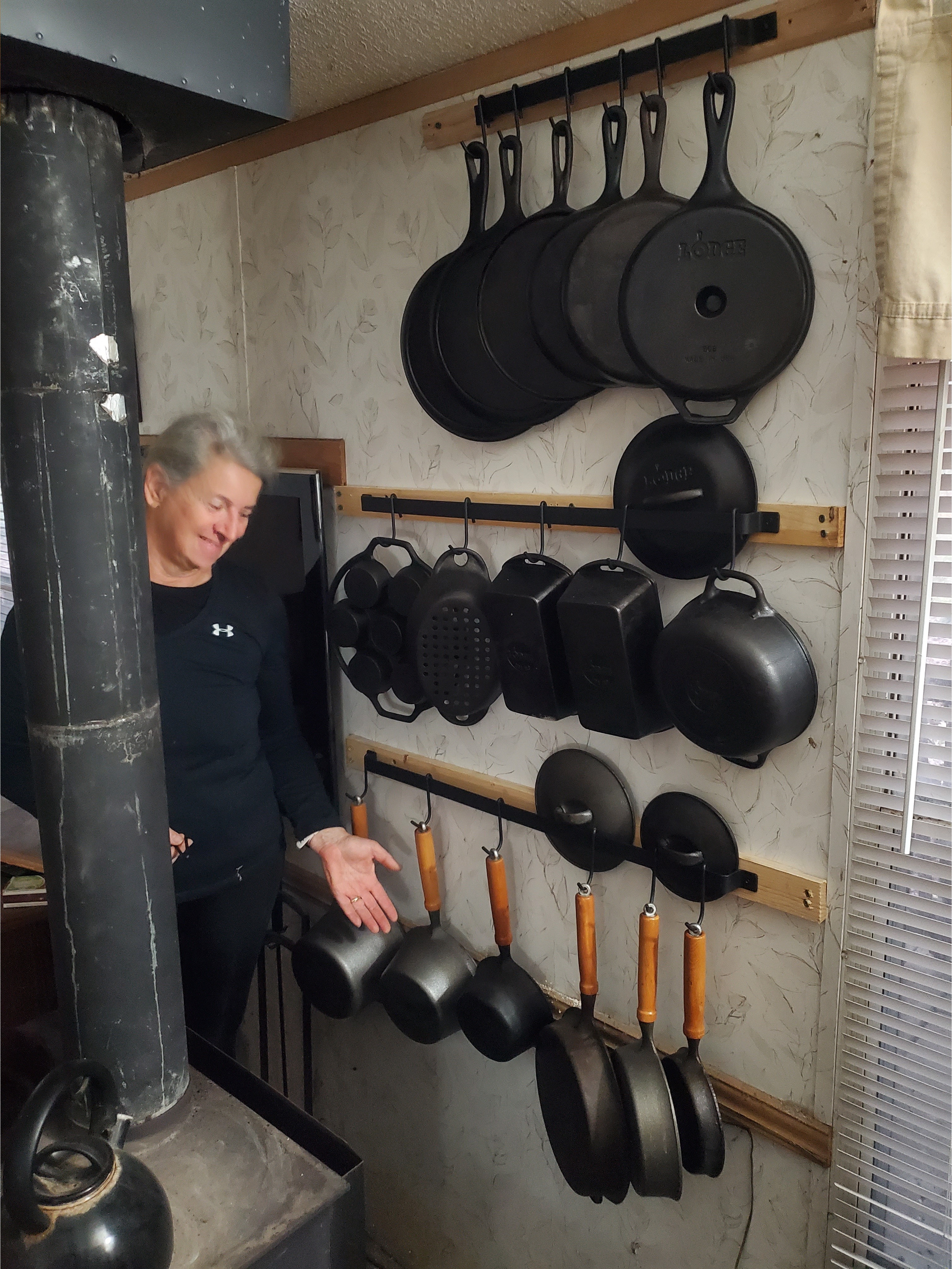 Cast iron cookery on the wall behind the wood stove